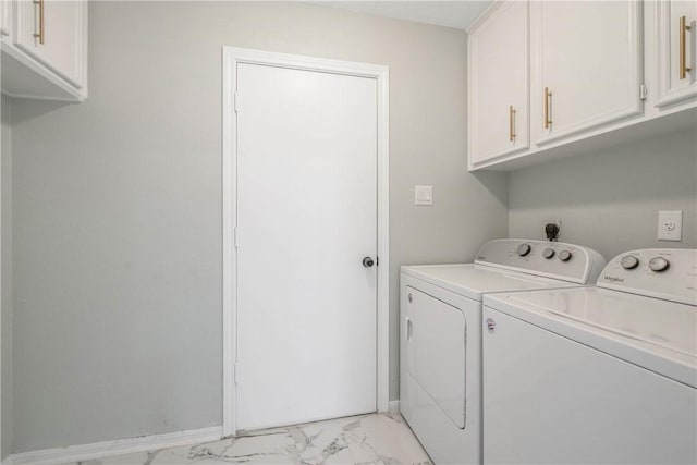 clothes washing area featuring marble finish floor, independent washer and dryer, cabinet space, and baseboards