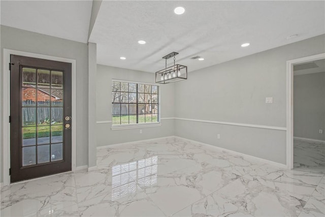 interior space featuring recessed lighting, marble finish floor, a textured ceiling, and baseboards