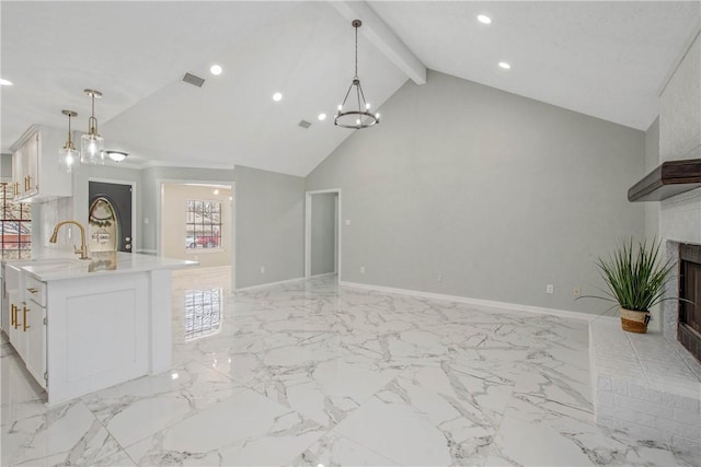 kitchen featuring hanging light fixtures, white cabinetry, light countertops, and open floor plan