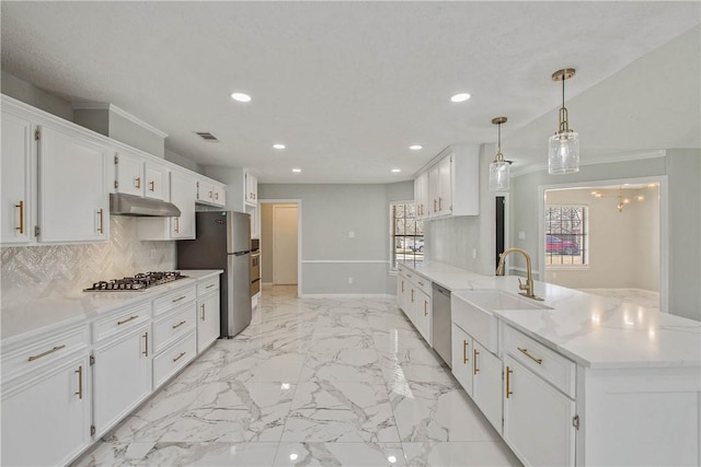 kitchen with pendant lighting, stainless steel appliances, white cabinetry, and under cabinet range hood