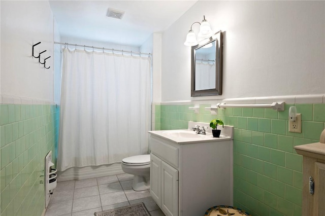 1210 Munson Ave, College Station, TX 77840 - full bath with tile walls, vanity, tile patterned flooring, a wainscoted wall, and toilet