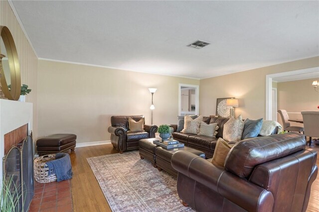 1210 Munson Ave, College Station, TX 77840 - living room with a fireplace, ornamental molding, wood finished floors, and a chandelier
