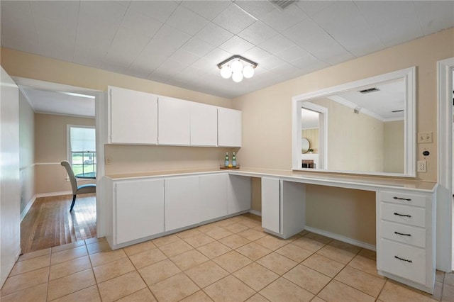 1210 Munson Ave, College Station, TX 77840 - kitchen featuring light countertops, white cabinetry, ornamental molding, baseboards, and light tile patterned flooring