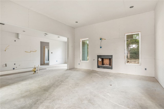 unfurnished living room with concrete flooring and a fireplace