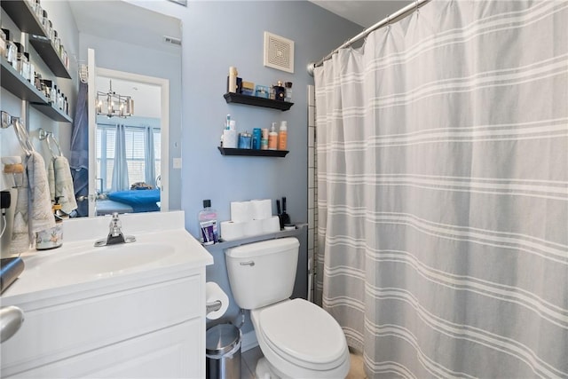 bathroom with vanity, curtained shower, an inviting chandelier, and toilet