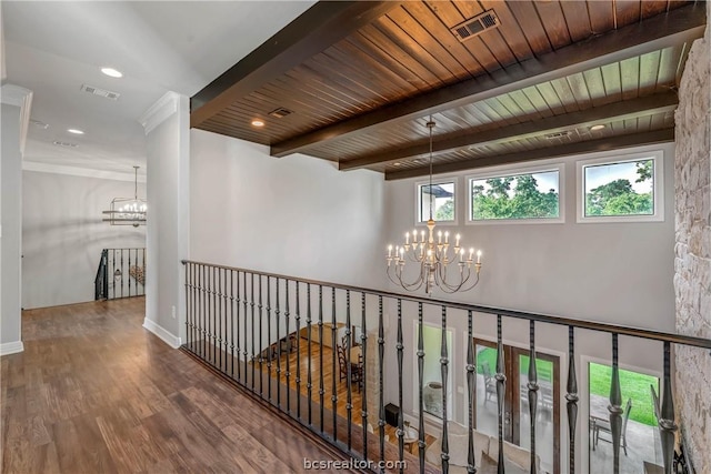 hallway with hardwood / wood-style flooring, a notable chandelier, beam ceiling, and wooden ceiling