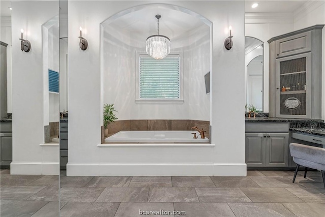 bathroom with a bathing tub, vanity, crown molding, and an inviting chandelier