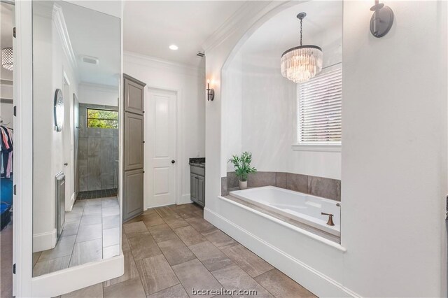 bathroom with a bathtub, vanity, a notable chandelier, and ornamental molding