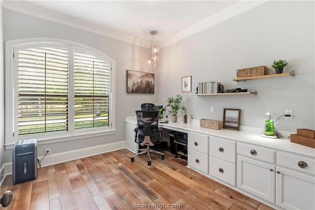 office area with crown molding, light hardwood / wood-style flooring, and built in desk