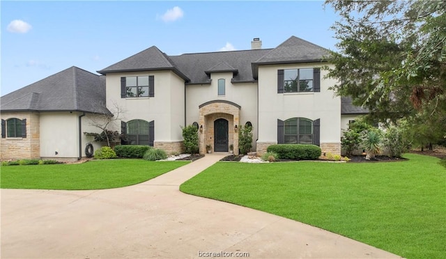 french provincial home with a front yard