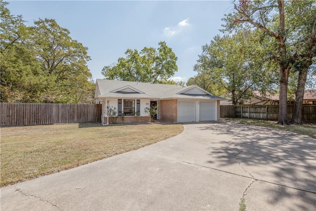 ranch-style home with an attached garage, fence, concrete driveway, and a front yard