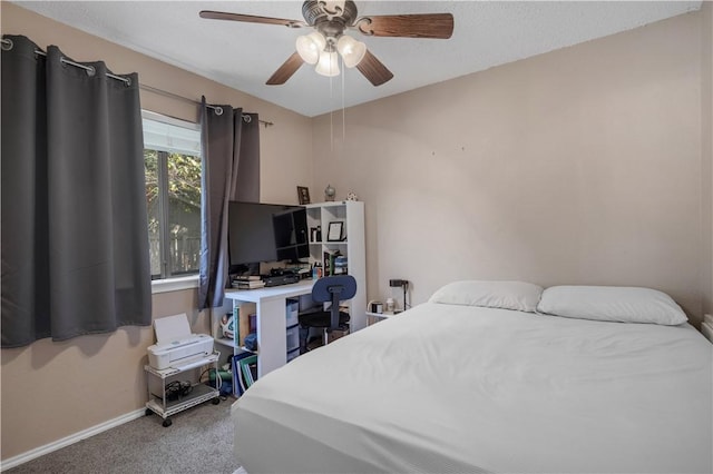 carpeted bedroom with ceiling fan and baseboards