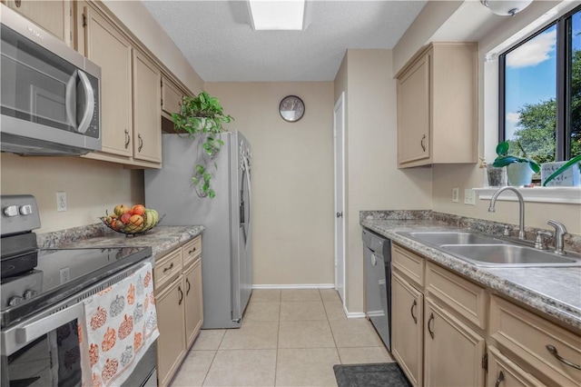 kitchen featuring light tile patterned floors, stainless steel appliances, light countertops, a sink, and a textured ceiling