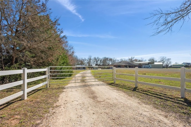 view of street featuring dirt driveway, a gated entry, a rural view, and a gate