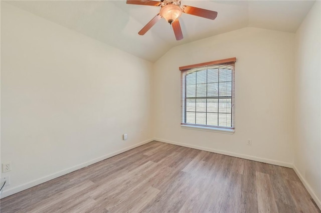 empty room with light wood-style floors, lofted ceiling, ceiling fan, and baseboards