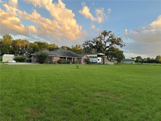 yard at dusk with driveway and an attached garage