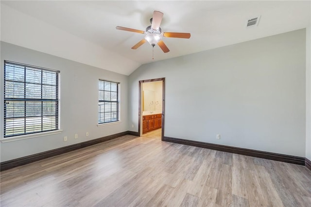 spare room with visible vents, baseboards, lofted ceiling, ceiling fan, and light wood-style floors