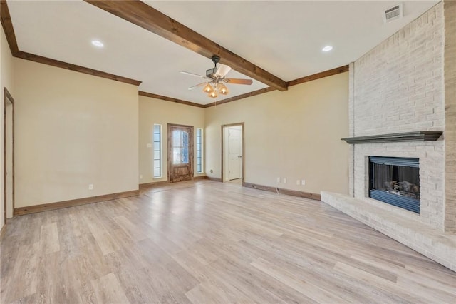 unfurnished living room featuring light wood-style floors, baseboards, visible vents, and beam ceiling