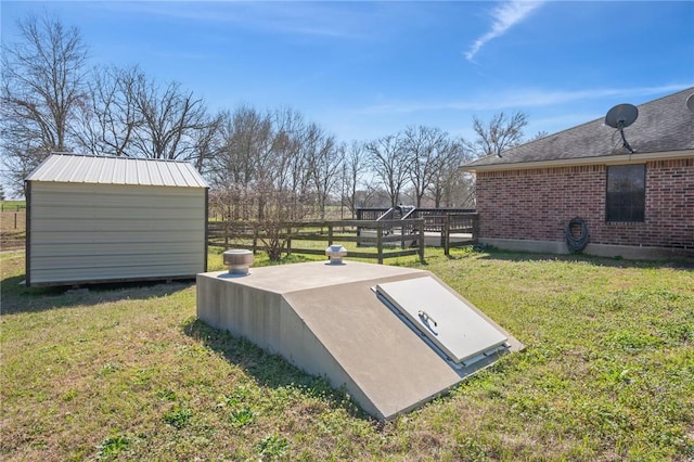 view of storm shelter featuring a storage shed, a lawn, and an outbuilding