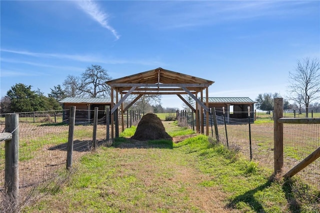 view of yard featuring an outbuilding, a rural view, and an exterior structure