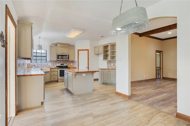 kitchen featuring decorative light fixtures, stainless steel appliances, backsplash, light wood-style flooring, and a kitchen island