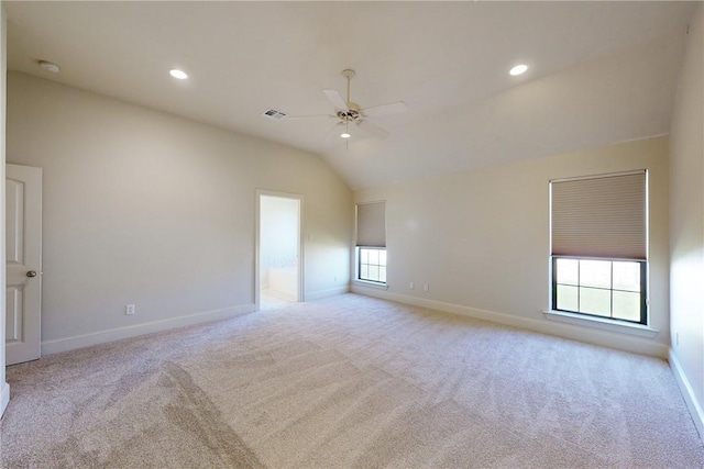 carpeted spare room with visible vents, baseboards, ceiling fan, and lofted ceiling