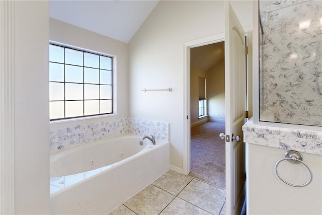 bathroom with a jetted tub, tile patterned flooring, and vaulted ceiling