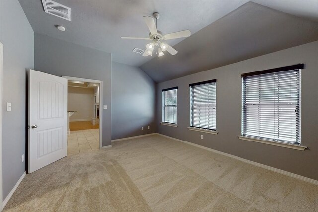 unfurnished room with light colored carpet, a ceiling fan, baseboards, lofted ceiling, and visible vents