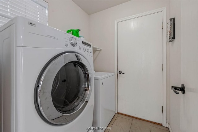 clothes washing area with washing machine and dryer and light tile patterned flooring