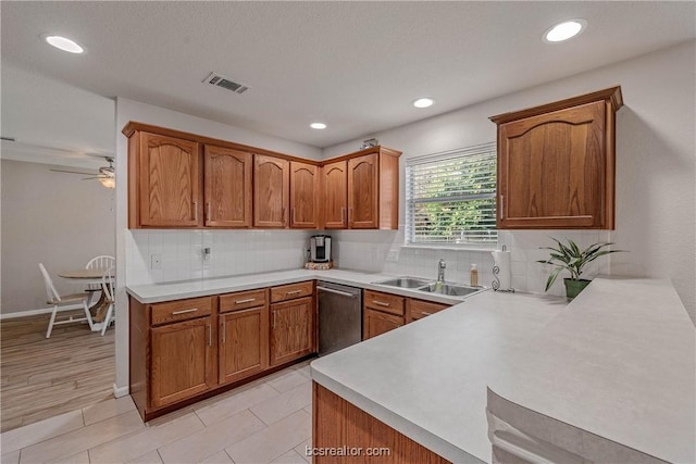 kitchen featuring dishwasher, decorative backsplash, kitchen peninsula, and sink