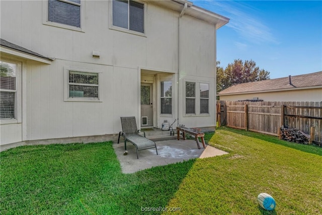 back of property with a yard and a patio area