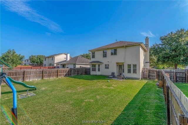 rear view of house with a playground and a yard