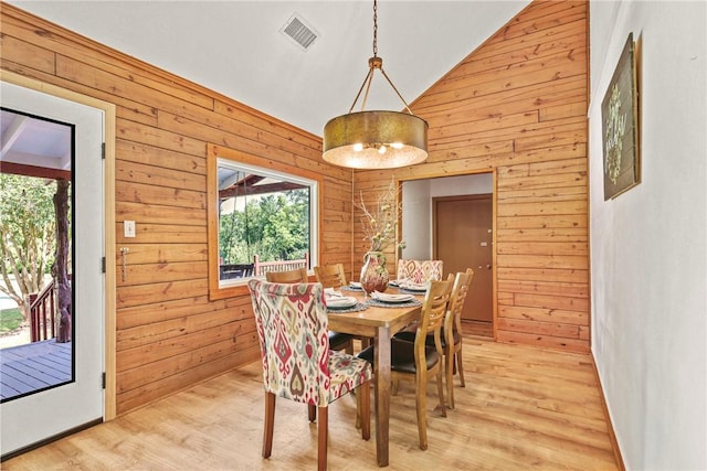 6508 Old Independence Rd, Brenham, TX 77833 - dining area featuring wooden walls, light wood finished floors, and high vaulted ceiling