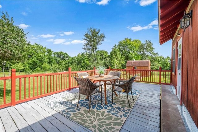 6508 Old Independence Rd, Brenham, TX 77833 - deck featuring outdoor dining area, a storage shed, an outbuilding, and a yard