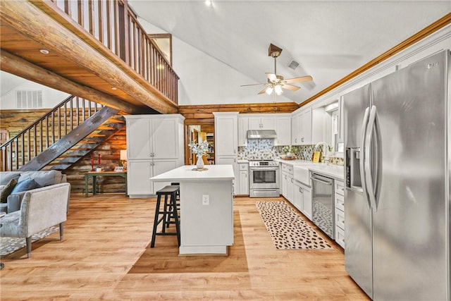 6508 Old Independence Rd, Brenham, TX 77833 - kitchen featuring appliances with stainless steel finishes, high vaulted ceiling, a kitchen island, ceiling fan, and a breakfast bar