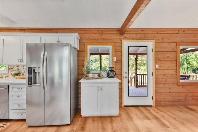 6508 Old Independence Rd, Brenham, TX 77833 - kitchen with stainless steel fridge with ice dispenser, beam ceiling, light wood-type flooring, wood walls, and light countertops
