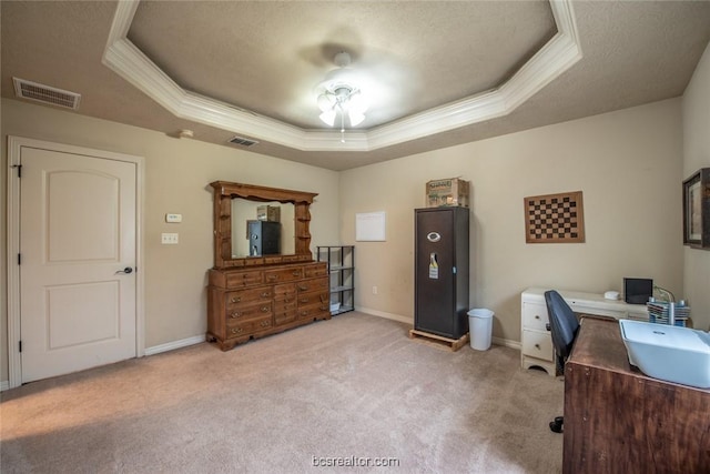 carpeted office featuring a raised ceiling, ceiling fan, crown molding, and a textured ceiling