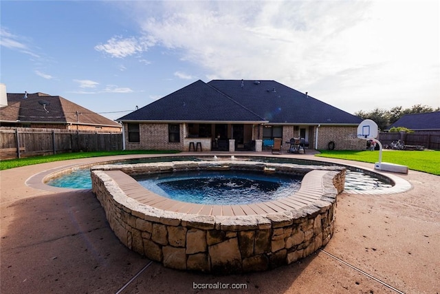 view of swimming pool featuring a patio area, a yard, and an in ground hot tub