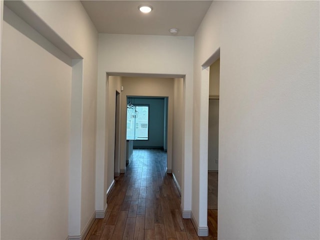 hall with baseboards and dark wood-style flooring