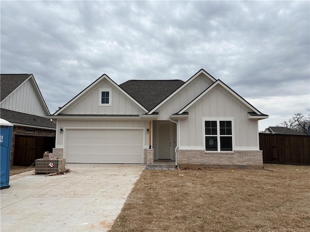 view of front of property featuring a garage, roof with shingles, board and batten siding, and fence