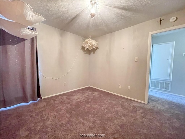 carpeted empty room featuring a textured ceiling