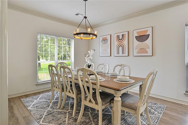 dining room with a chandelier, visible vents, baseboards, ornamental molding, and light wood-type flooring