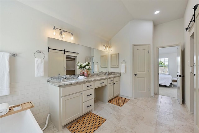6209 Cromwell Ct, Bryan, TX 77802 - bathroom featuring double vanity, a soaking tub, lofted ceiling, ensuite bath, and tile walls
