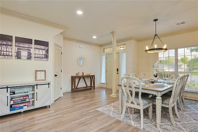 dining area with ornamental molding, hardwood / wood-style flooring, ornate columns, and a notable chandelier