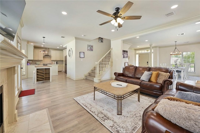 living room with ceiling fan, light hardwood / wood-style floors, and ornamental molding