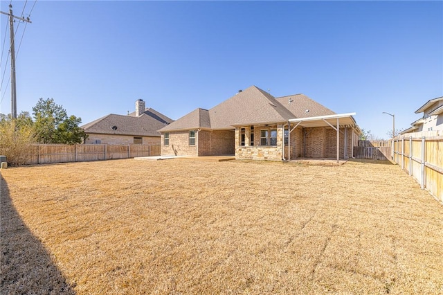 rear view of property featuring a yard