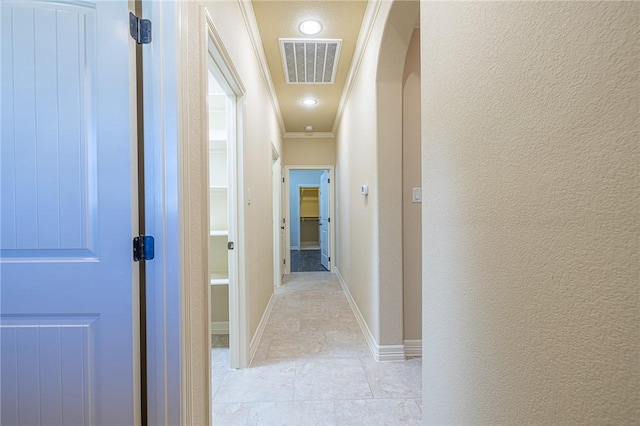 corridor featuring crown molding and light tile patterned floors