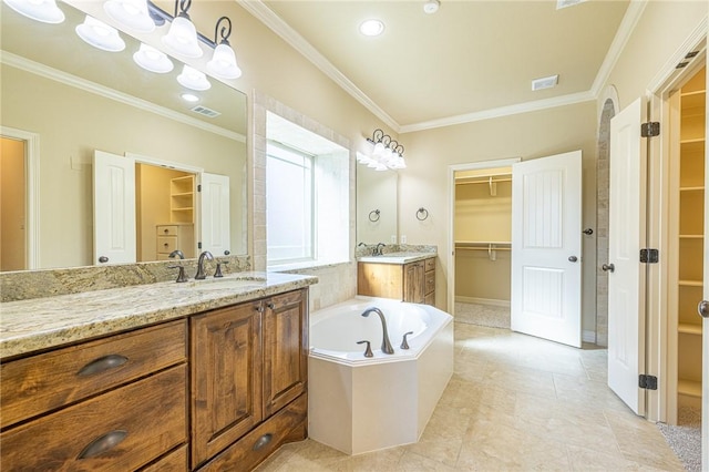 bathroom featuring vanity, ornamental molding, and tiled bath