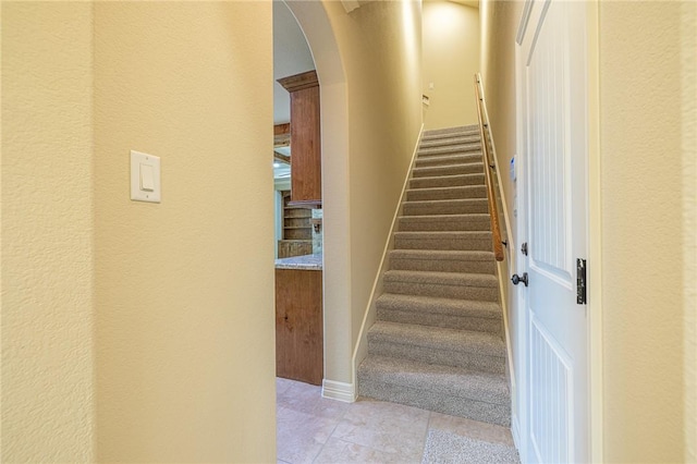 stairway with tile patterned floors