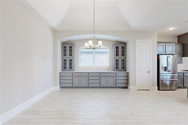 unfurnished dining area with a notable chandelier and lofted ceiling